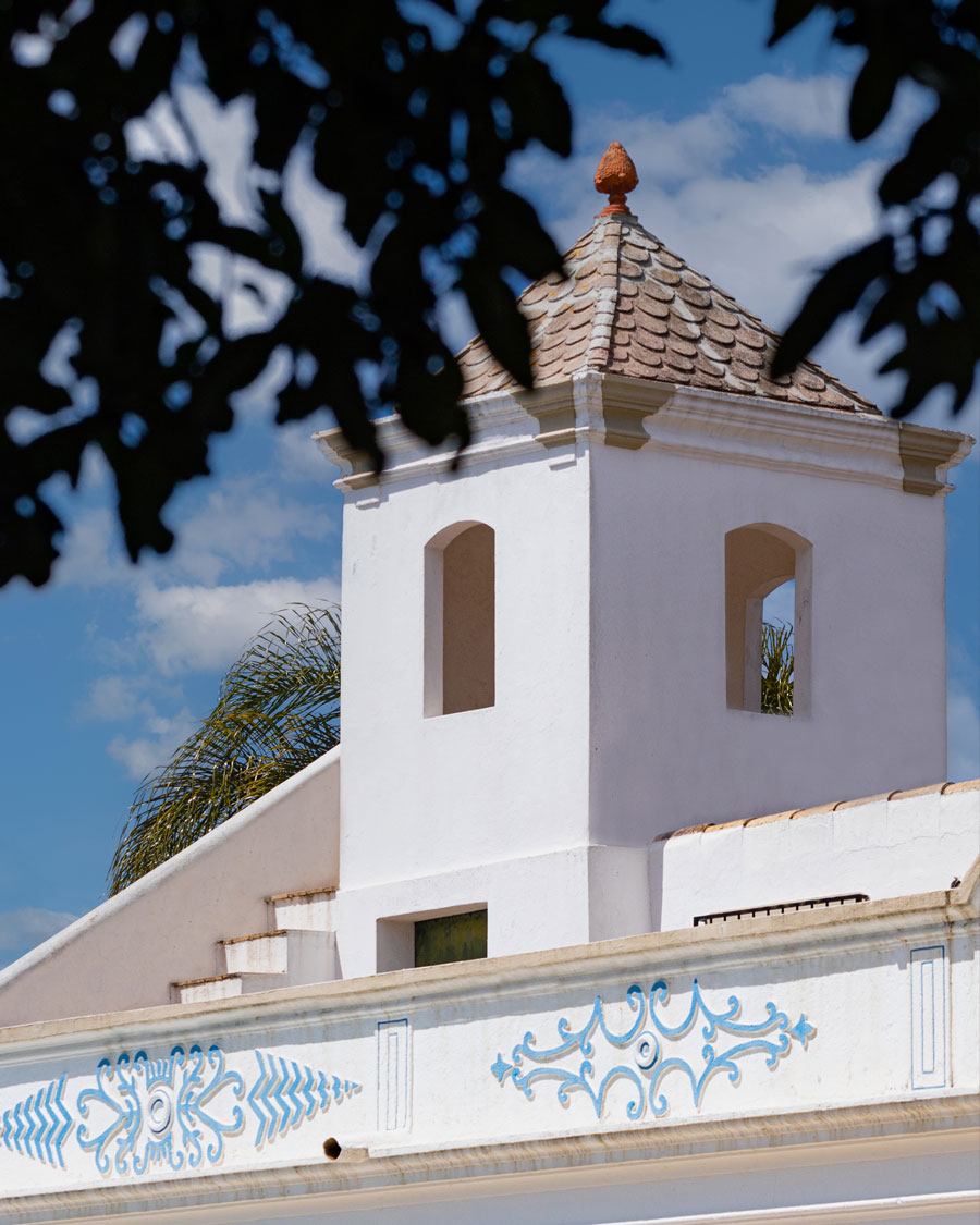 White building with decorative blue patterns and tower.