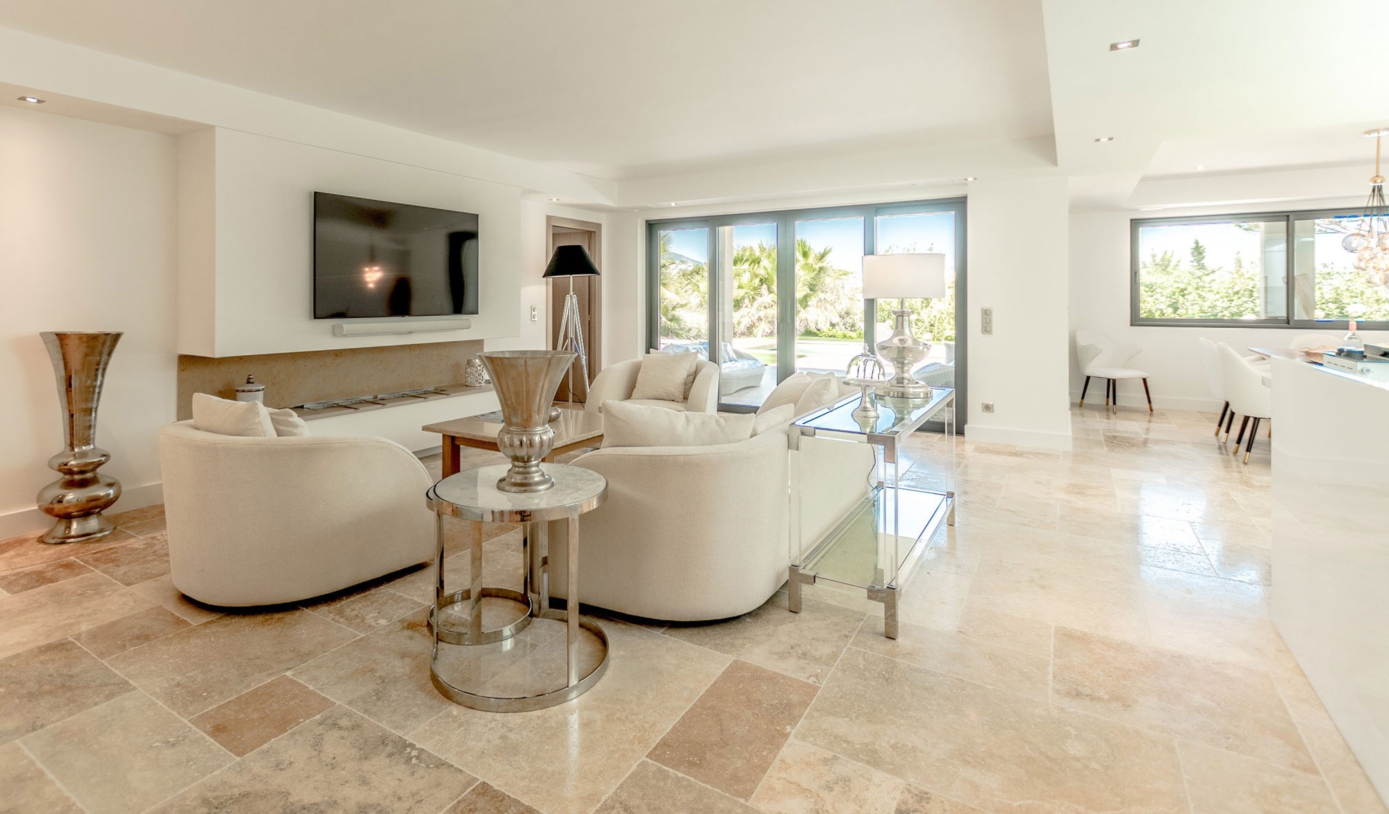 Modern living room with large windows and TV.