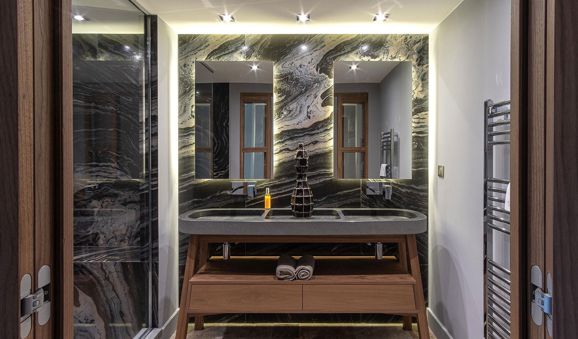 Modern bathroom with double sink and mirrors.