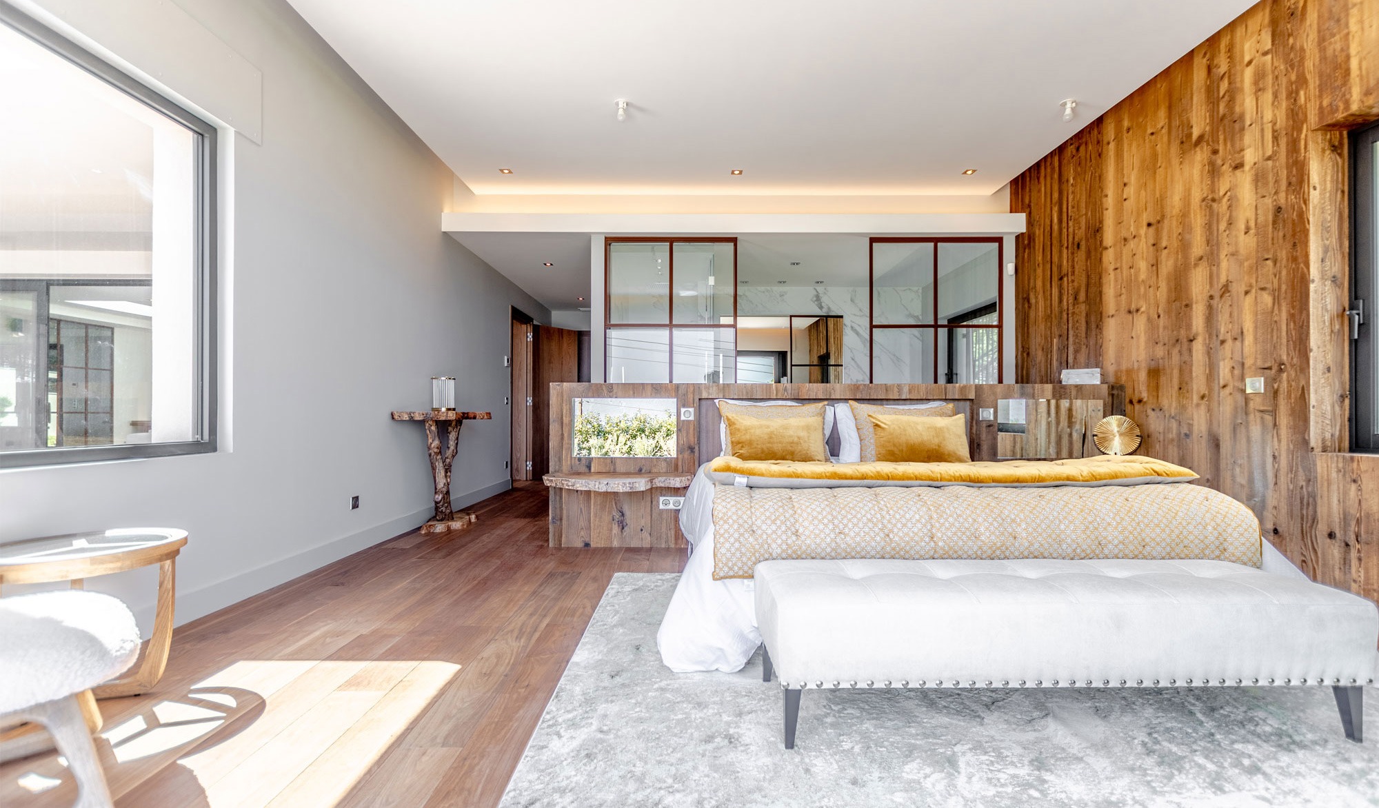 Modern bedroom with wooden decor and large window.